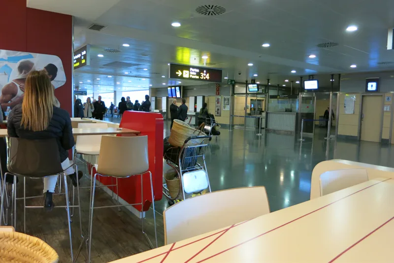 Reisende und Wegweiser zu den Flugsteigen im Flughafen Ibiza