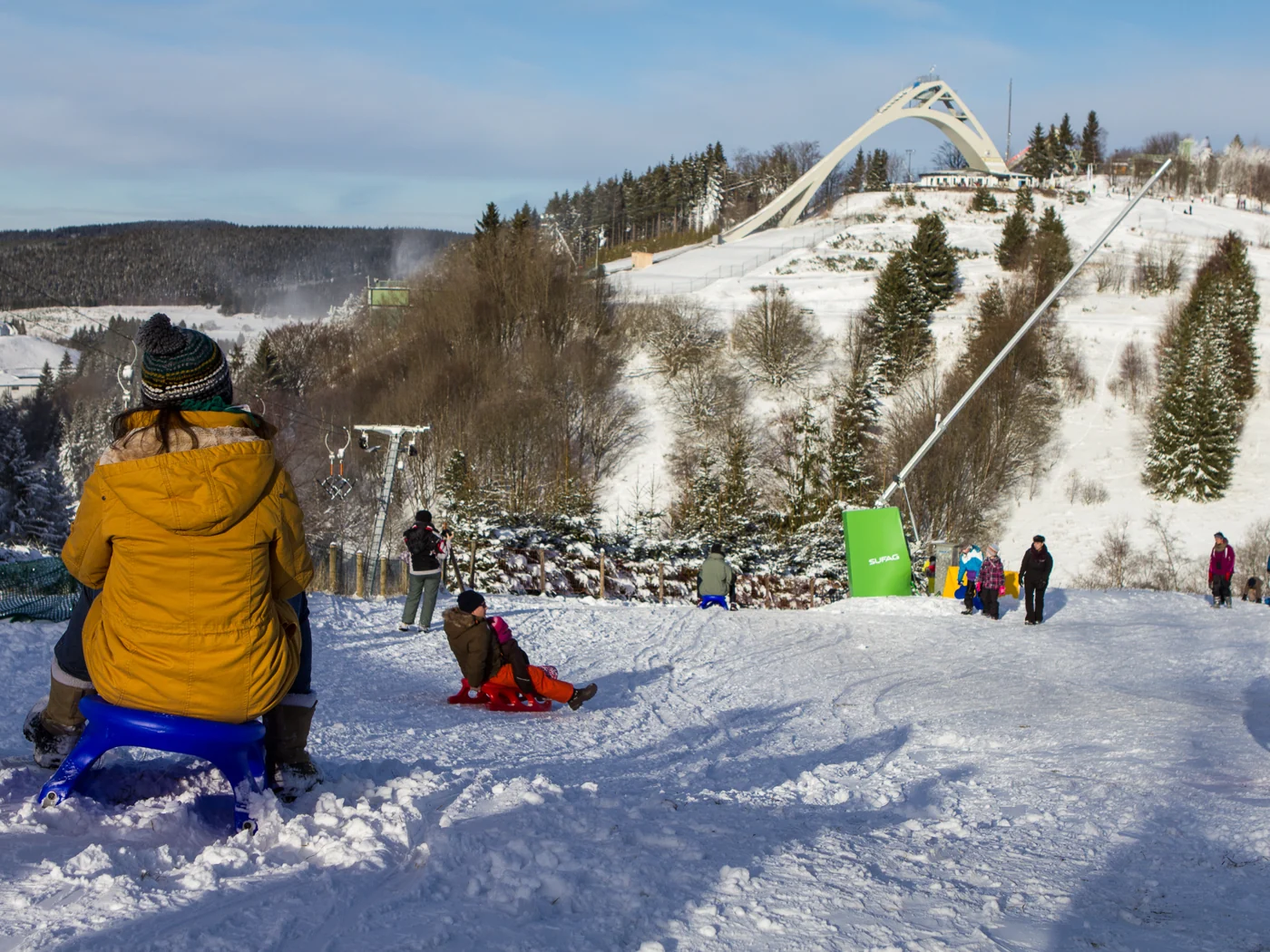 Skigebiet mit verschneiter Piste und Wintergästen